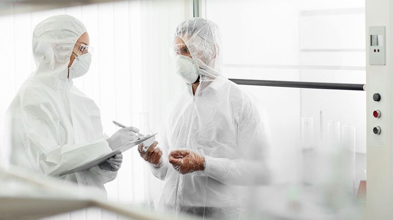 Two scientist full white gown taking notes